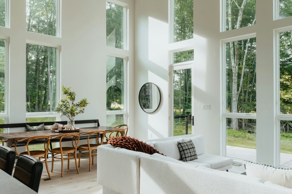 Luxurious living room in a modern luxury home featuring floor-to-ceiling windows that highlight timeless design and expert craftsmanship.