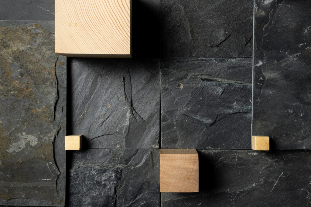 Close-up of natural stone tiles paired with light wood accents, showcasing a modern, eco-conscious material combination.